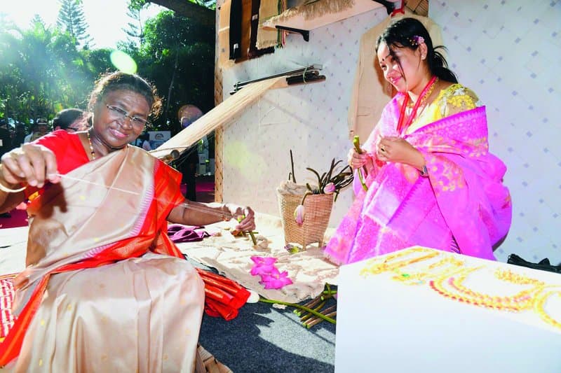 President Droupadi Murmu tries her hand at lotus fibre extraction with Bijiyashanti Tongbram.